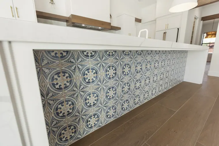 Kitchen island faced in blue-and-white patterned tile