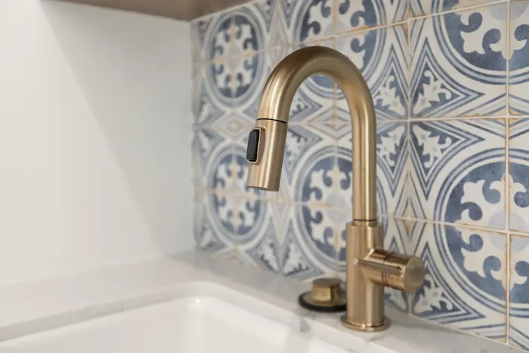 Brass faucet against patterned tile