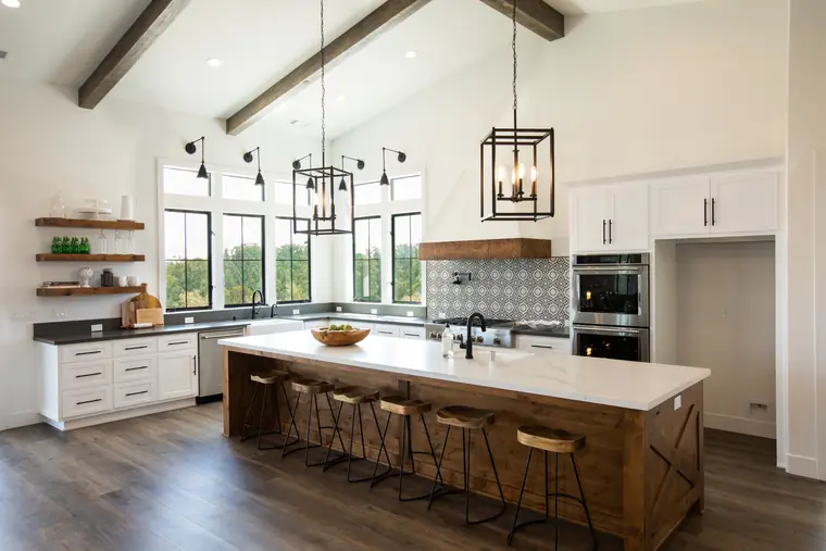 Kitchen with a long wood island and black-framed windows