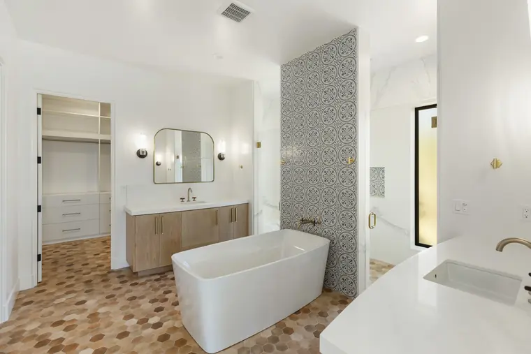 Primary bath with a freestanding tub and tiled feature wall