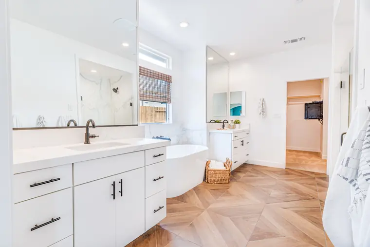 Primary bath with a freestanding tub and wood-look tile floor