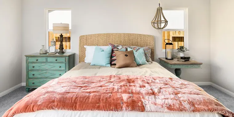 Bedroom with a woven headboard and coral bedding