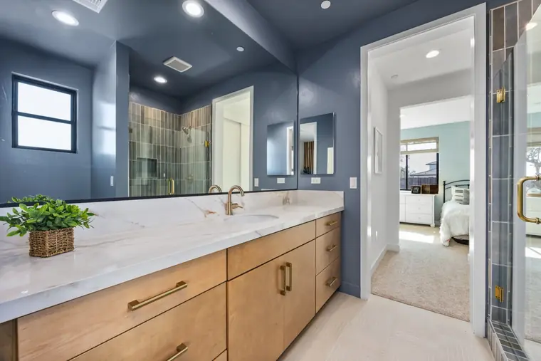 Bathroom with a navy accent wall and wood vanity