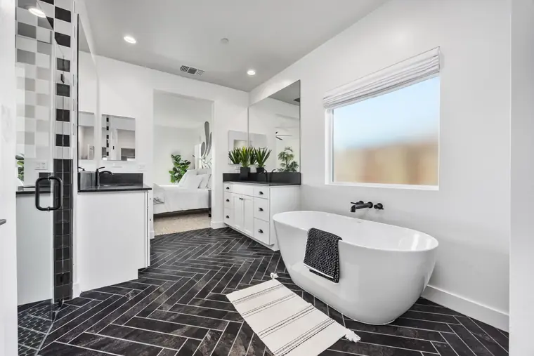 Primary bath with a freestanding tub and herringbone tile floor