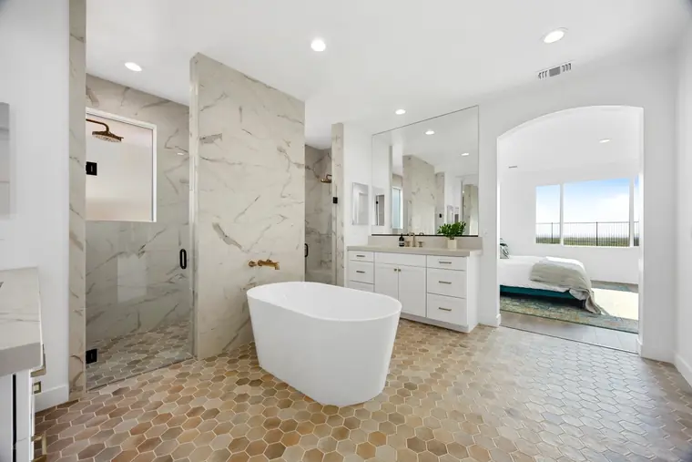 Primary bath with a freestanding tub and marble-look walk-in shower