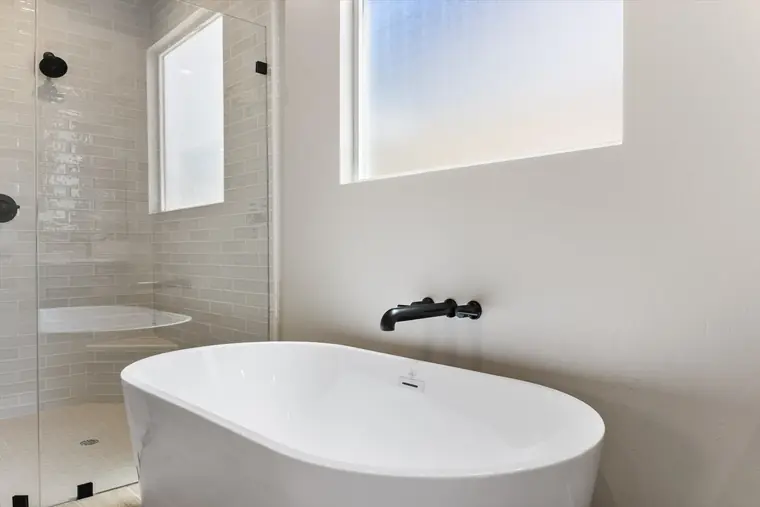 Freestanding tub with black fixtures in a primary bath
