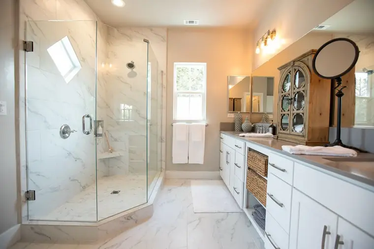 Primary bath with a frameless glass shower and dual vanity