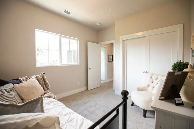 Bedroom with a reading chair and wrought-iron bed