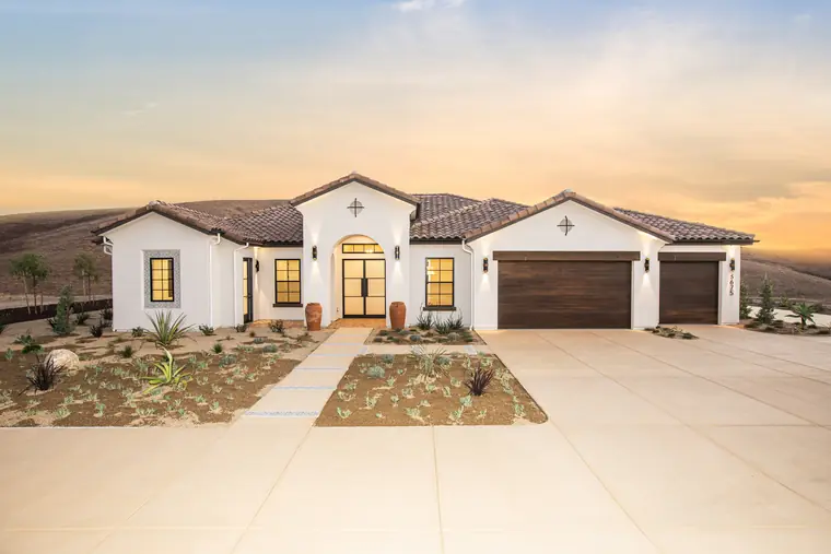 Spanish-style home at sunset with a clay tile roof