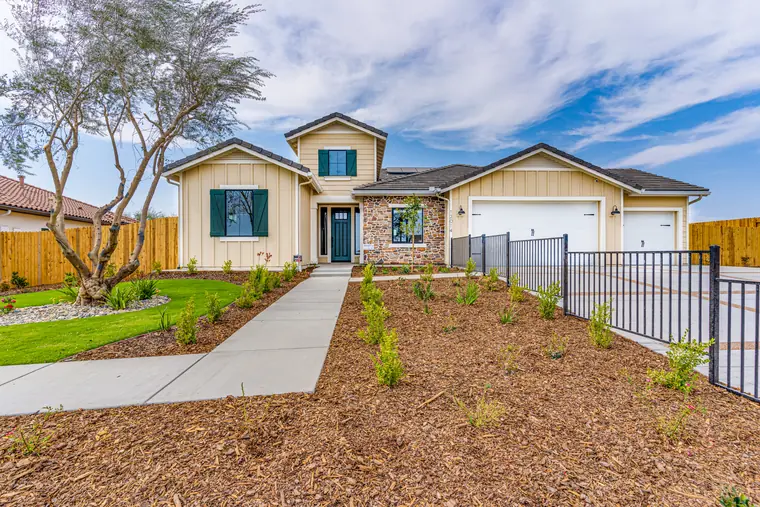 Model home with stone accents and a landscaped front yard