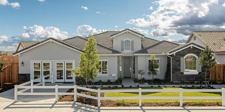 Single-story home with stone accents and a white rail fence