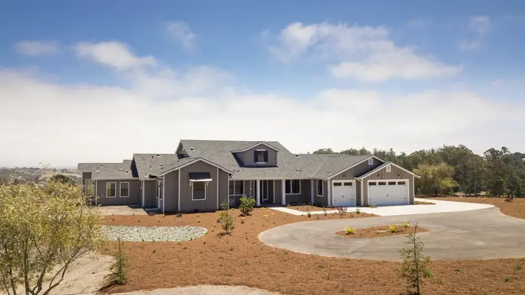 Single-story home on a large lot with a long driveway