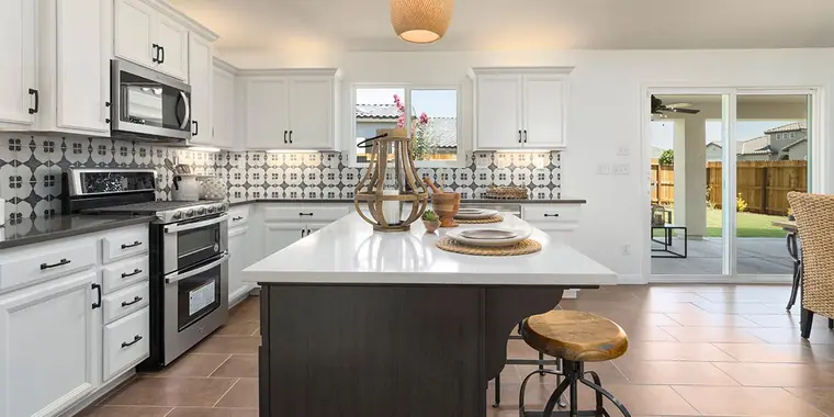 Kitchen with a patterned tile backsplash and a dark island
