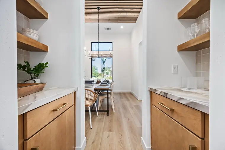 Butler's pantry with open wood shelves and a marble counter