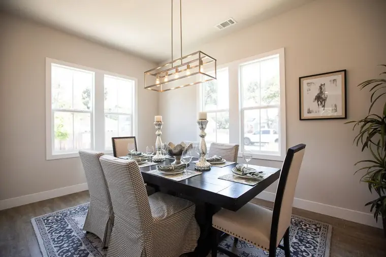 Dining area with a rectangular chandelier and tall windows
