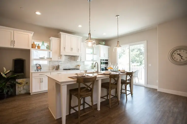 White kitchen with a seated island and pendant lights