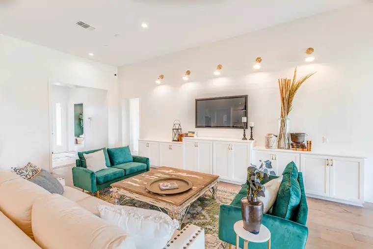 Family room with built-in cabinets and green velvet chairs