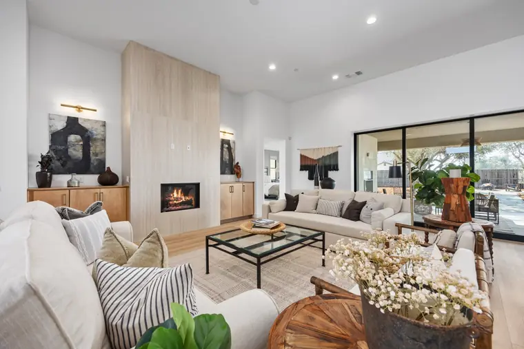 Great room with a stone fireplace wall and white sofas