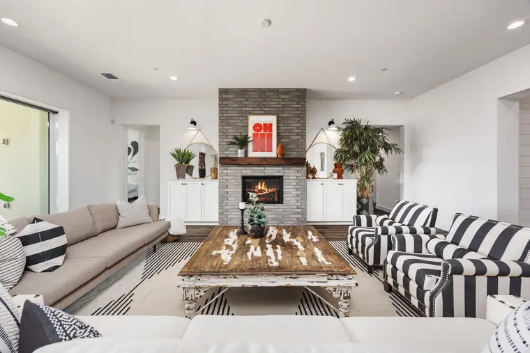 Living room with a brick fireplace and striped armchairs