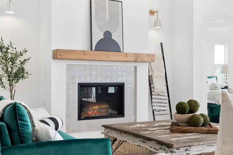 Tiled fireplace with a wood mantel in the great room