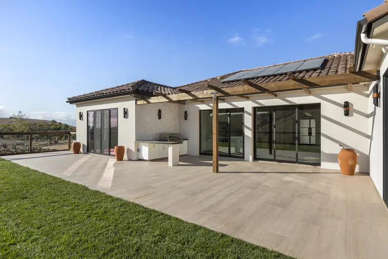 Pergola-covered patio and lawn behind a Central Coast home