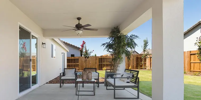 Covered patio with a ceiling fan and seating