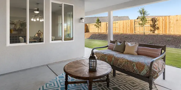 Covered patio with a daybed and lawn beyond