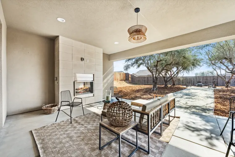 Covered patio with an outdoor fireplace and dining table